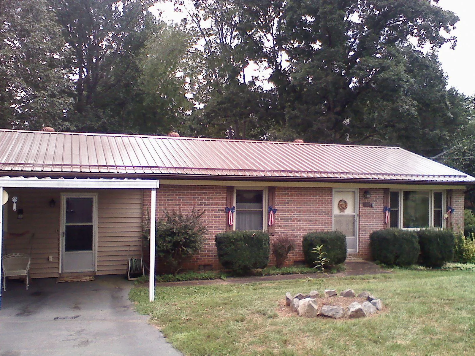 Bronze metal roof and carport on a brick ranch home — Roof Repair work by our crew in Buena